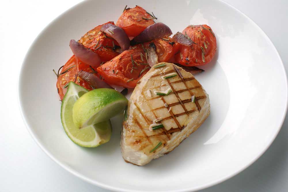 Seared Tuna with Roasted Rosemary Tomatoes - recipe. Rosemary, lime and garlic are used to marinate the fresh tuna, served with sweet roasted tomatoes
