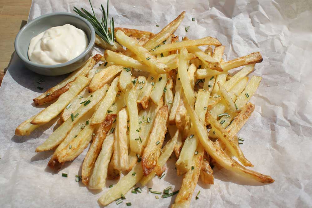 Crispy Oven Baked Fries with Rosemary Salt. The potatoes are oven cooked in coconut oil, making them a healthy side dish.