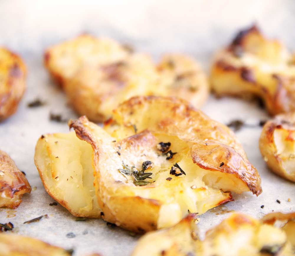 Smashed Crispy Thyme Potatoes. These potatoes are the perfect mix. Creamy soft centres with crisp crunchy edges. Seasoned well with sea salt and thyme they make the perfect accompaniment to so many meals.