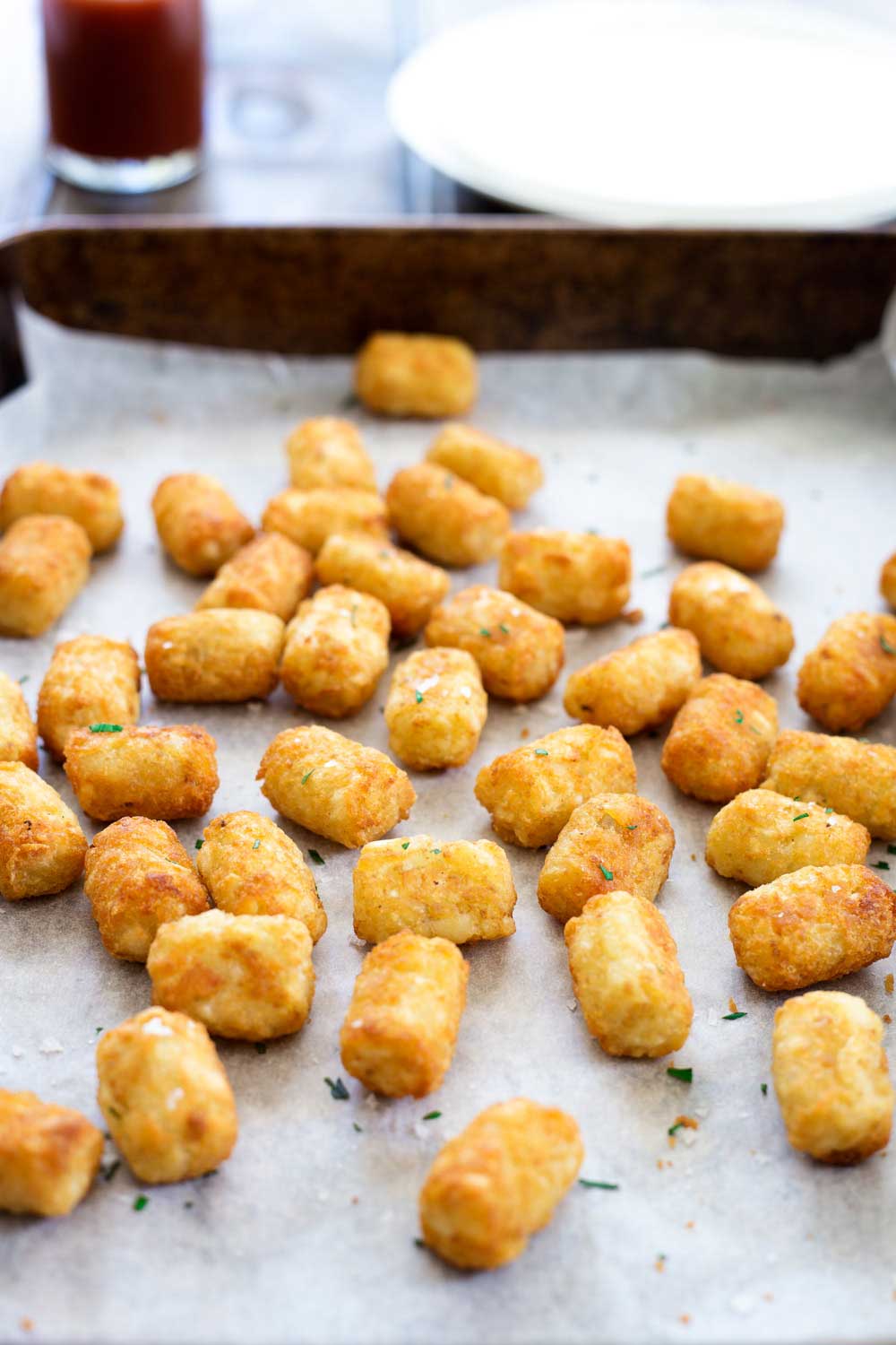 a metal tray of cooked tater tots
