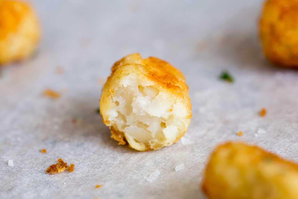 close up on the indie of a cooked potato tot