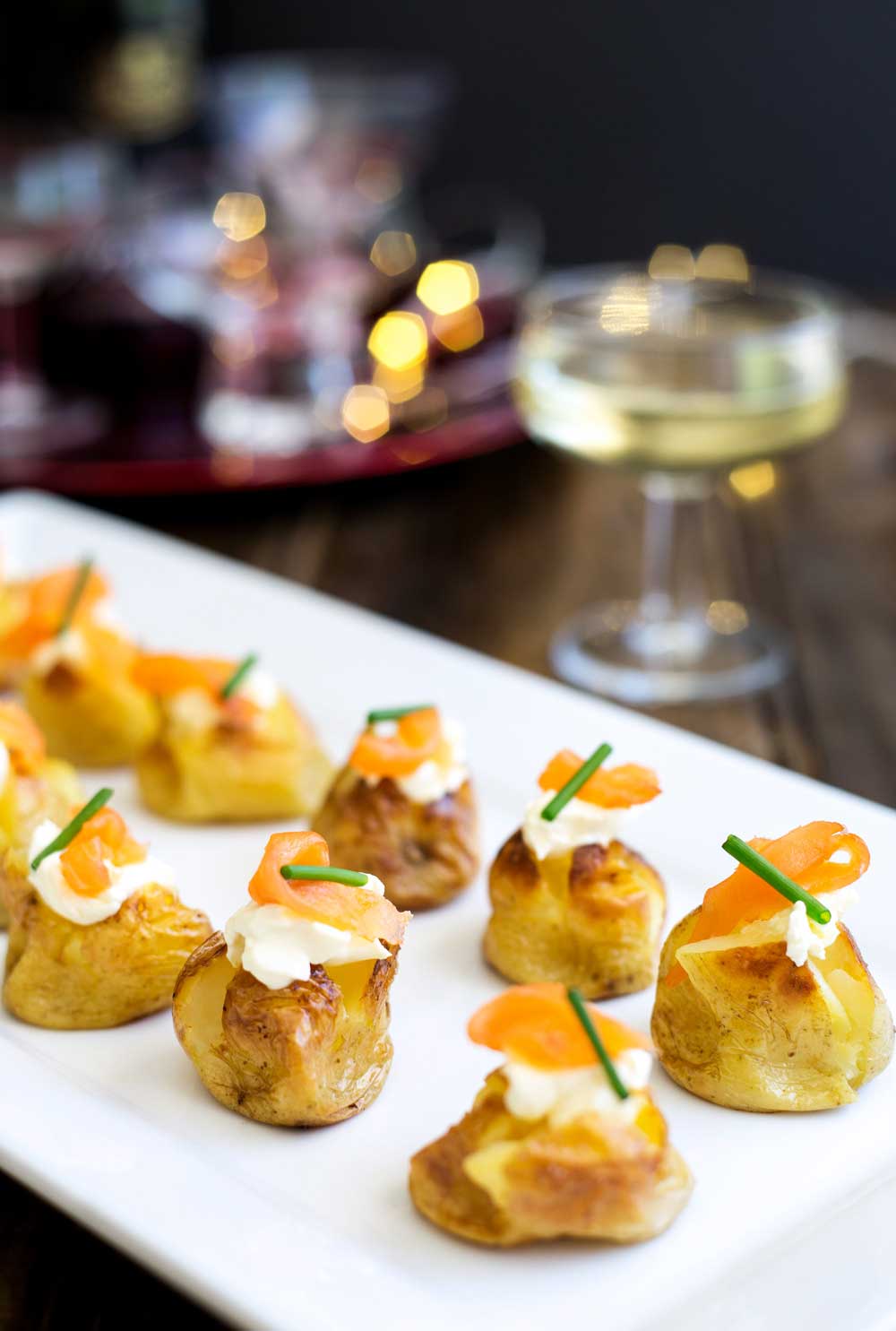 These mini baked potatoes with smoked salmon and sour cream are perfect for parties. Simple yet impressive. You can prepare them ahead or stick them in the oven as your guests arrive, making them perfect for New Year Parties.