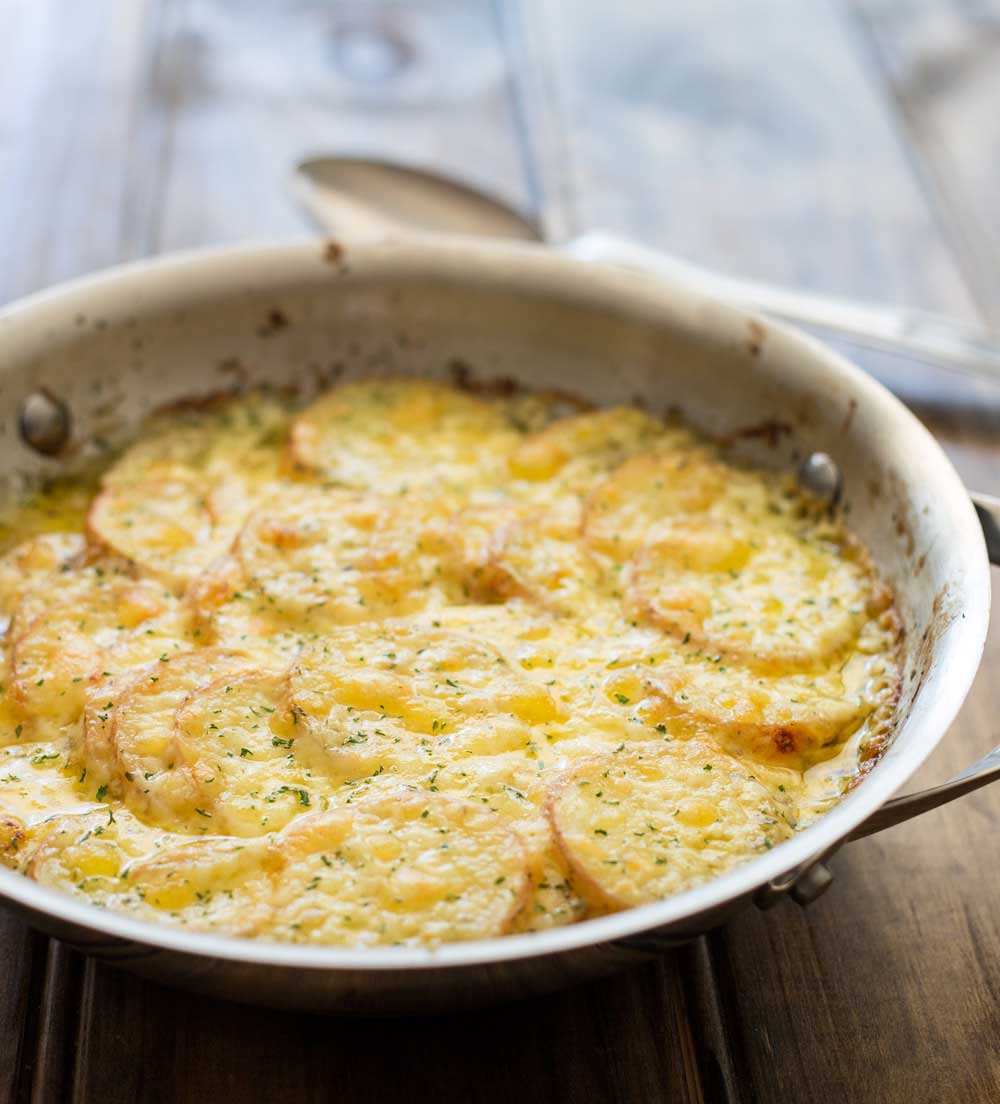 Cheesy Layered Potatoes. Potatoes, cream and cheese. Seriously what could be better? Layers of potato and onion cooked in cream and stock until tender and then smothered in cheese and baked to a melty, creamy perfection. This is comfort food at it's very best! | Sprinkles and Sprouts