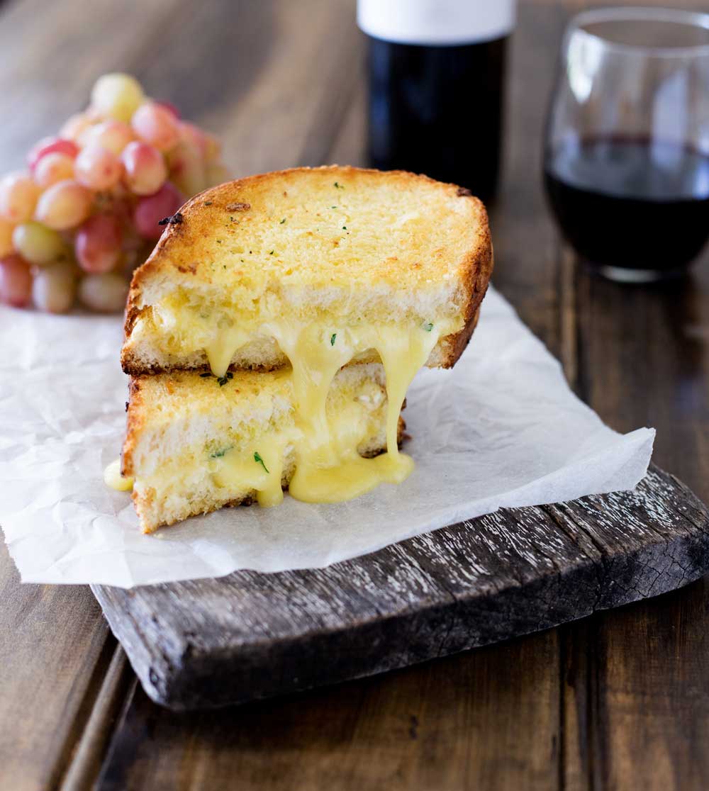 Cheesy garlic bread sandwiches. Garlic butter smothered bread filled with soft brie, crisped and browned to melting gooey perfection. Perfection! I kid you not, this is a sandwich that will make you lick the plate!!! 
