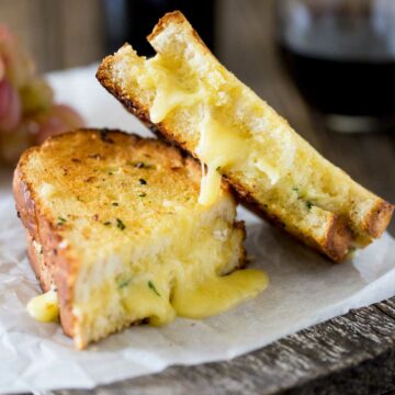 Cheesy garlic bread sandwiches. Garlic butter smothered bread filled with soft brie, crisped and browned to melting gooey perfection. Perfection! I kid you not, this is a sandwich that will make you lick the plate!!!