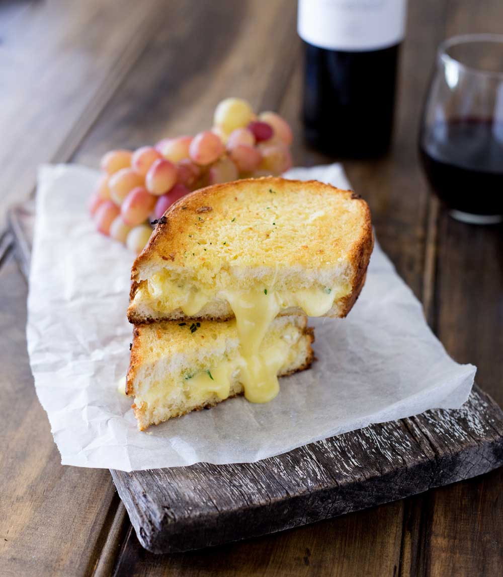Cheesy garlic bread sandwiches. Garlic butter smothered bread filled with soft brie, crisped and browned to melting gooey perfection. Perfection! I kid you not, this is a sandwich that will make you lick the plate!!! 