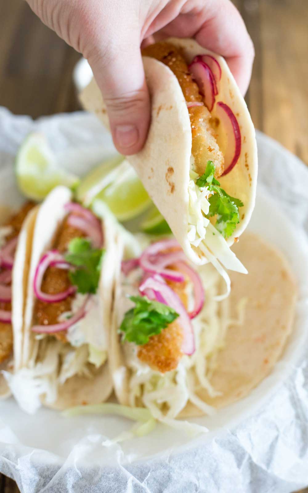 These fish tacos are taco heaven! Soft flour tortillas are filled with crispy fish, sweet and sour brown sugar onions and an amazing creamy taco sauce. 