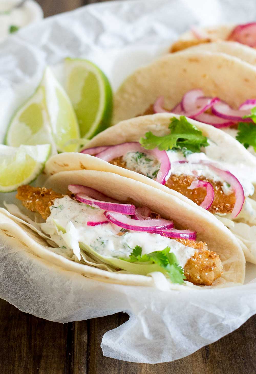 These fish tacos are taco heaven! Soft flour tortillas are filled with crispy fish, sweet and sour brown sugar onions and an amazing creamy taco sauce. 