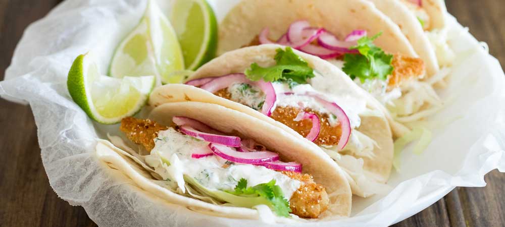 These fish tacos are taco heaven! Soft flour tortillas are filled with crispy fish, sweet and sour brown sugar onions and an amazing creamy taco sauce.