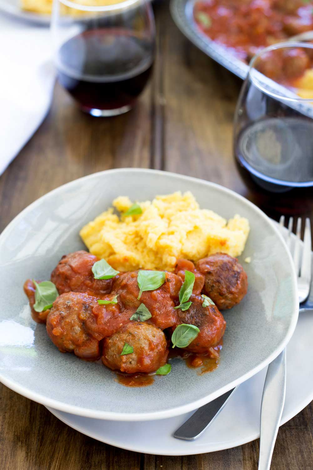 Soft, light, juicy baked Italian meatballs, baked in a rich tomato sauce and served with soft cheesy polenta. This is comfort food at it's very best. The meatballs are so tender and packed full of flavour!