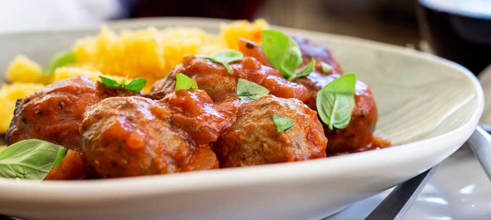 Soft, light, juicy baked Italian meatballs, baked in a rich tomato sauce and served with soft cheesy polenta. This is comfort food at it's very best. The meatballs are so tender and packed full of flavour!