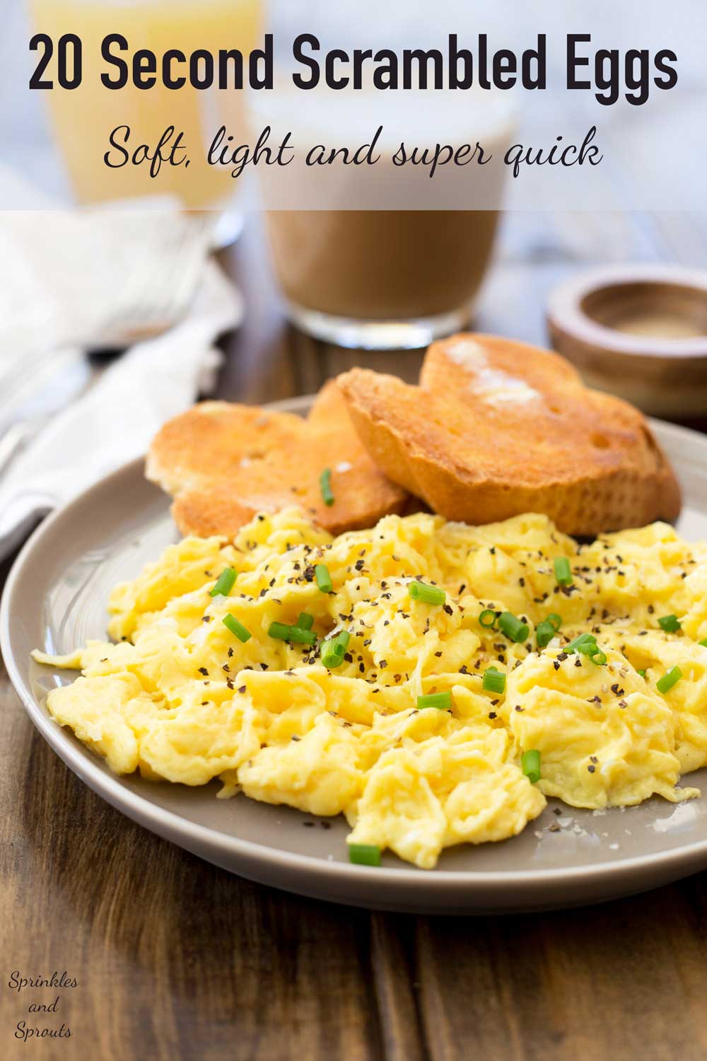 Scrambled eggs on a grey plate with toast and coffee in the background