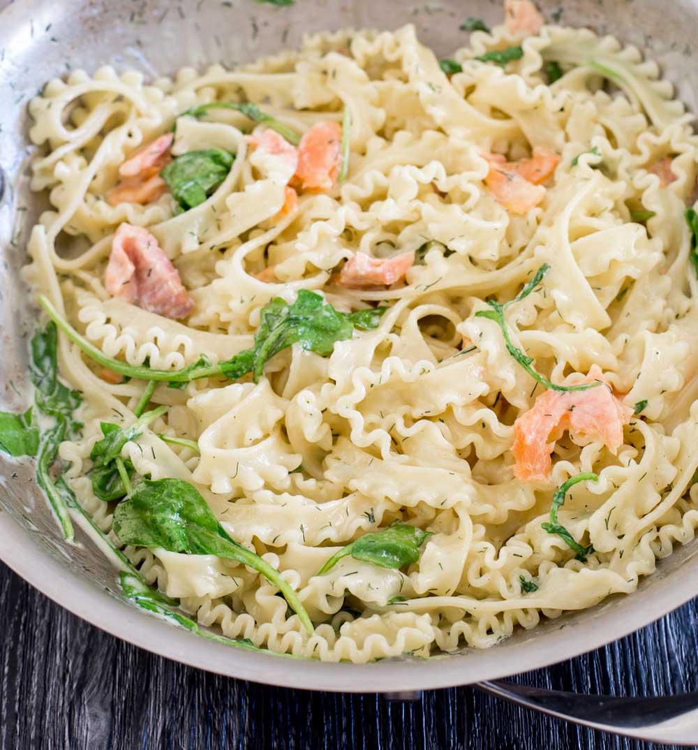 a silver pan of pasta with smoked salmon and spinach it