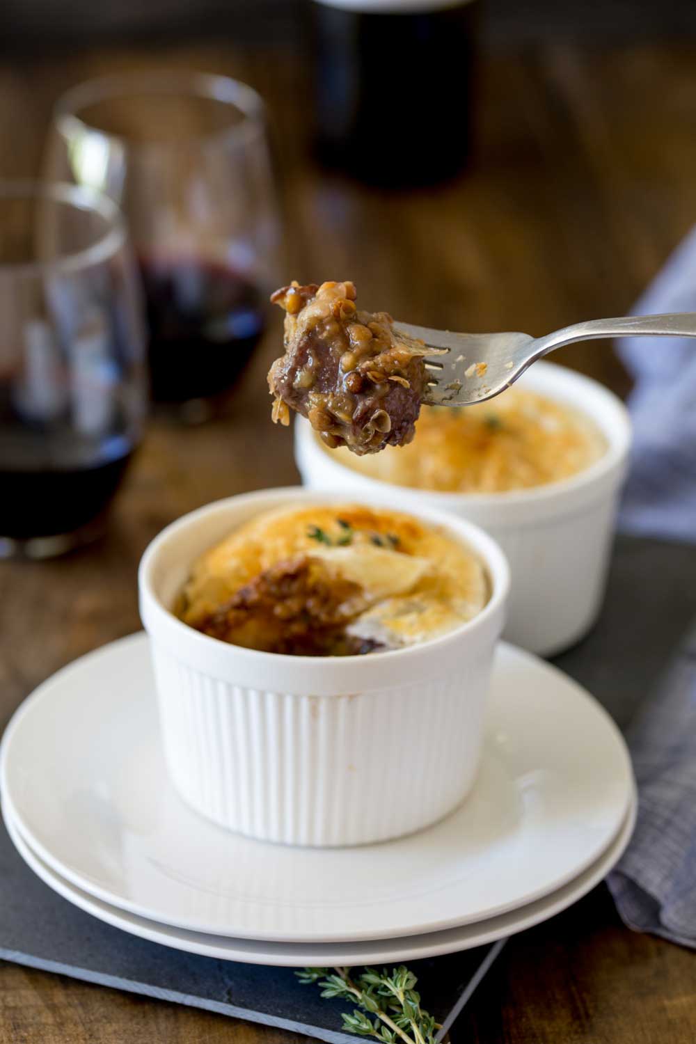 Meaty sausages, hearty lentils, fragrant thyme and rich red wine. All cooked together and covered with a disk of buttery puff pastry. This sausage and lentil pot pie is comfort in a bowl!