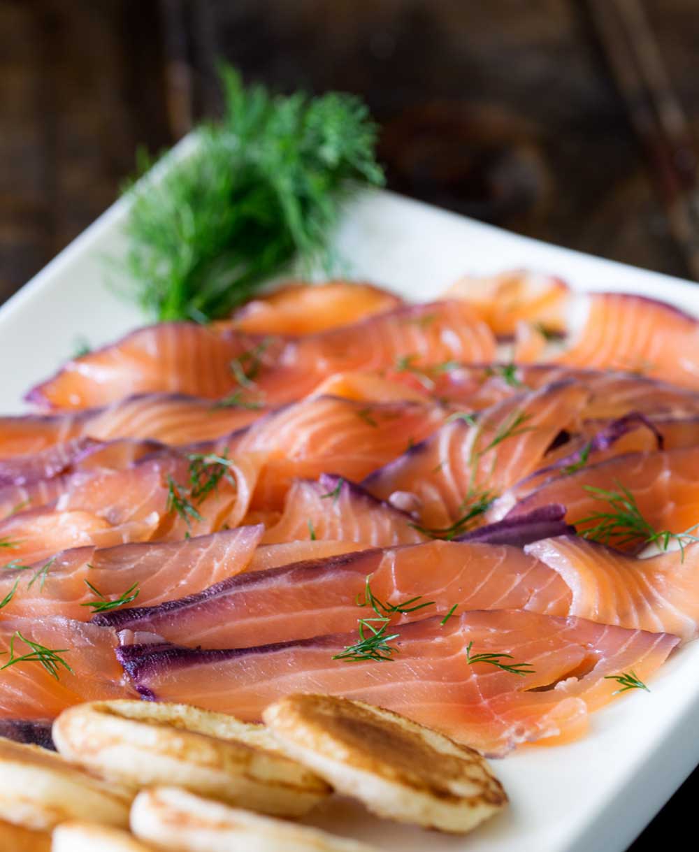 Home cured salmon. A delicious twist on a traditional gravlax. Fruity blueberries, spicy notes of dill and a salty sweet edge. This cured salmon is beautiful and delicious.