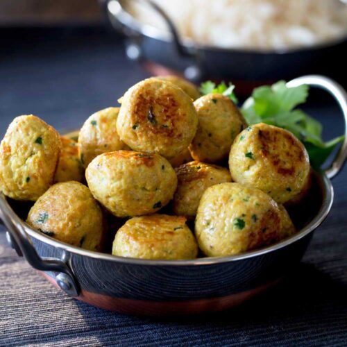 close up on small meatballs in a metal bowl with handles