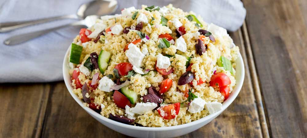 Close up of the tomatoes and cucumber in this greek couscous salad.