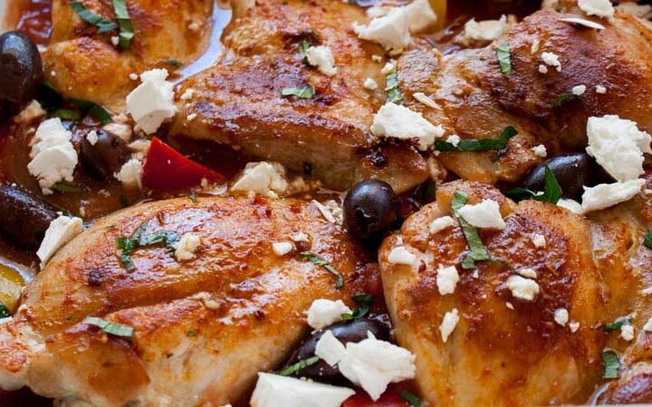 One pan Greek chicken in a rich tomato sauce packed with onion and capsicums. Baked in the oven and then topped with crumbled feta, briny olives and fresh oregano. This Greek chicken dish is perfect for feeding your family. Add some buttered couscous, maybe a green salad and some bread and you have a Greek feast!!!!