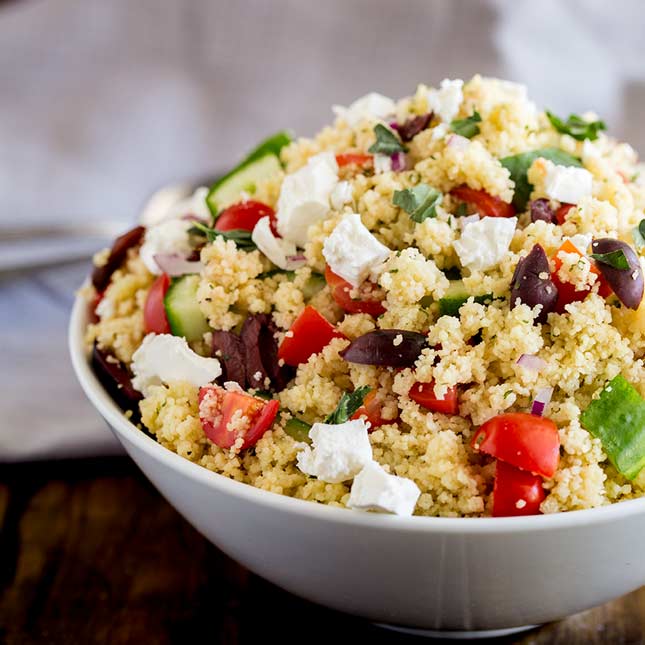 white bowl with couscous and greek veg