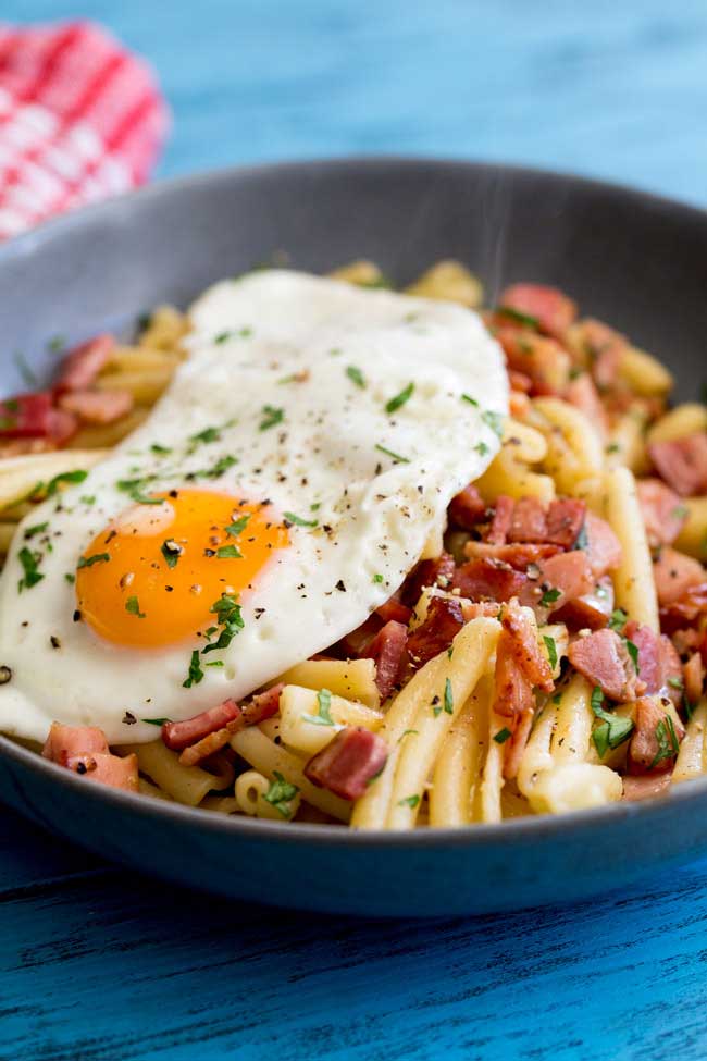 Salty, smokey bacon stirred through buttered pasta and dressed with a soft egg. The yolk oozes over the pasta and creates a fabulous additional sauce. This Brunch pasta dish is simple to make, delicious to eat and costs pennies to make! Winner!!!