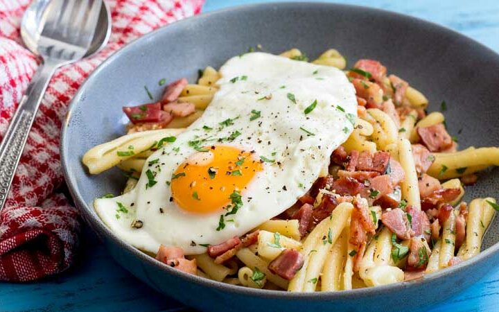 Salty, smokey bacon stirred through buttered pasta and dressed with a soft egg. The yolk oozes over the pasta and creates a fabulous additional sauce. This Brunch pasta dish is simple to make, delicious to eat and costs pennies to make! Winner!!!