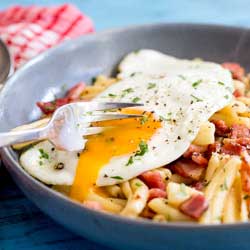 Salty, smokey bacon stirred through buttered pasta and dressed with a soft egg. The yolk oozes over the pasta and creates a fabulous additional sauce. This Brunch pasta dish is simple to make, delicious to eat and costs pennies to make! Winner!!!