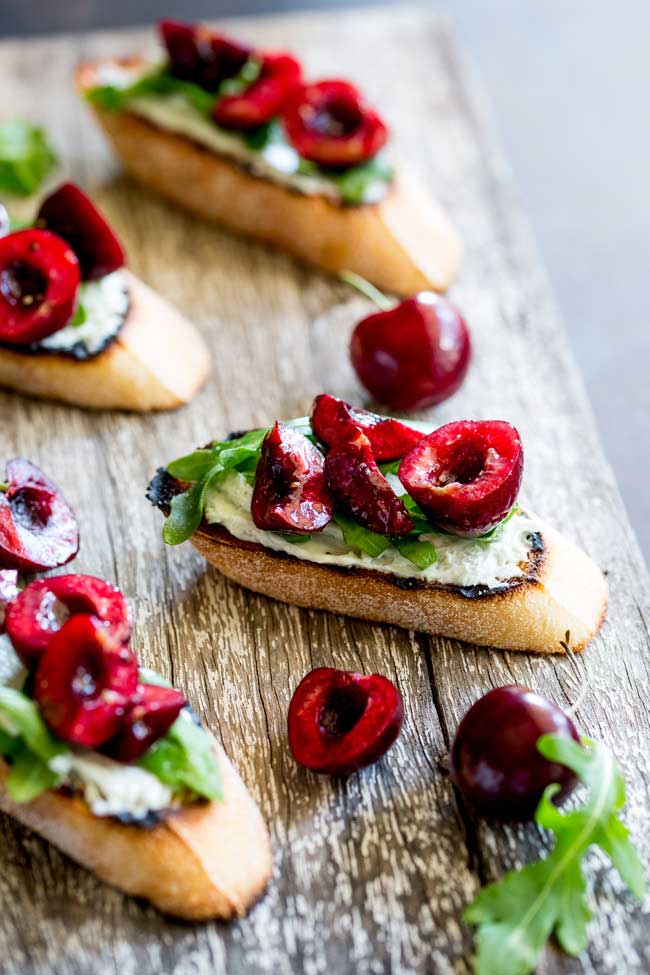 Creamy, salty blue cheese, peppery rocket and sweet juicy cherries. These Blue Cheese Bruschetta with Cherry Salsa are a delicious snack or appetiser. When cherries are at their ripest, these bruschetta are the perfect thing to make. The sweet fruity cherry is the perfect partner to the rich blue cheese. Cheese and fruit are a match made in heaven! 