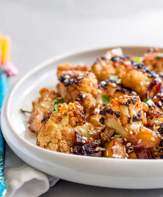 This Oven Baked Honey Soy Sesame Cauliflower is an umami rich dish, full of sticky, sweet flavours that will delight vegetarians and meat eaters alike. It is quick to prepare and then happily bakes in the oven. From Sprinkles and Sprouts