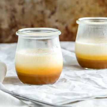 SQ picture showing two glass jars with a layered salted caramel and vanilla panna cotta in them
