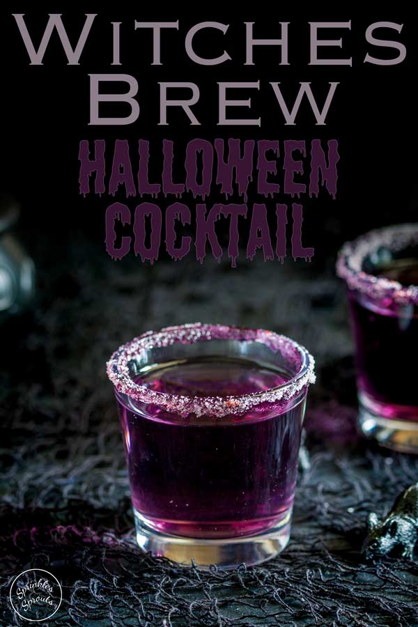 purple liquid in a small shot glass rimmed with sugar sat on a black halloween table