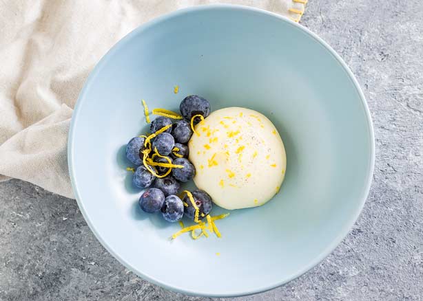 Lemon Panna Cotta in a pale blue bowl.