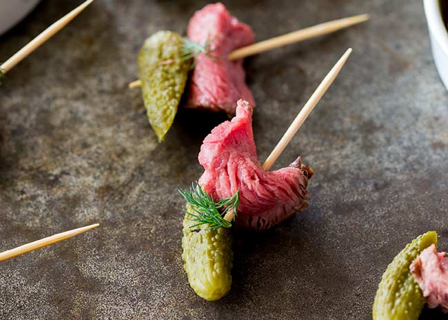 close up on a single skewer, showing the tender dill pickle beef cut across the grain