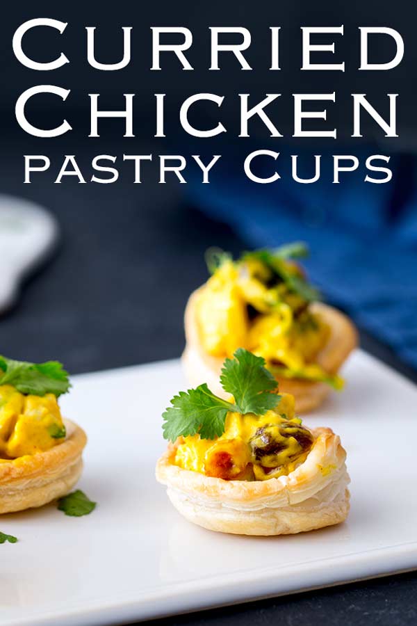 Pinterest image, White platter with pastry cups filled with curried chicken and text at the top