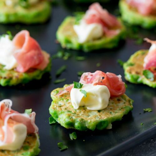 an overhead SQ picture showing the smooth mascarpone and curl of prosciutto on the pea fritter