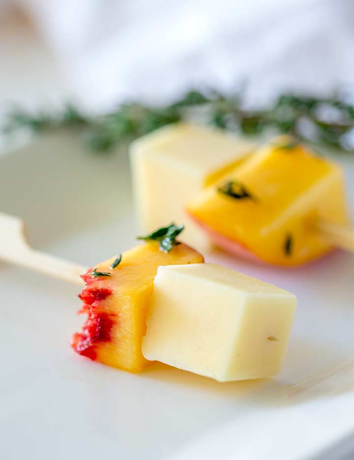 close up on the cube of gouda on the gouda and peach skewers