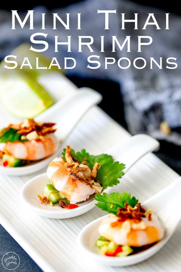 for pinterest, showing 3 canapé spoons on a white plate, with thai cucumber salad on the bottom and a shrimp on top.