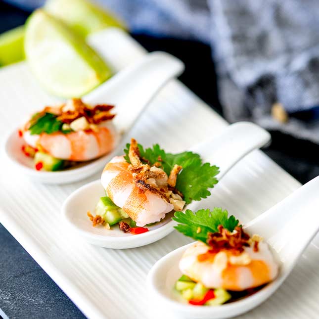 showing the finely diced salad under the shrimp on the spoon canapé spoons