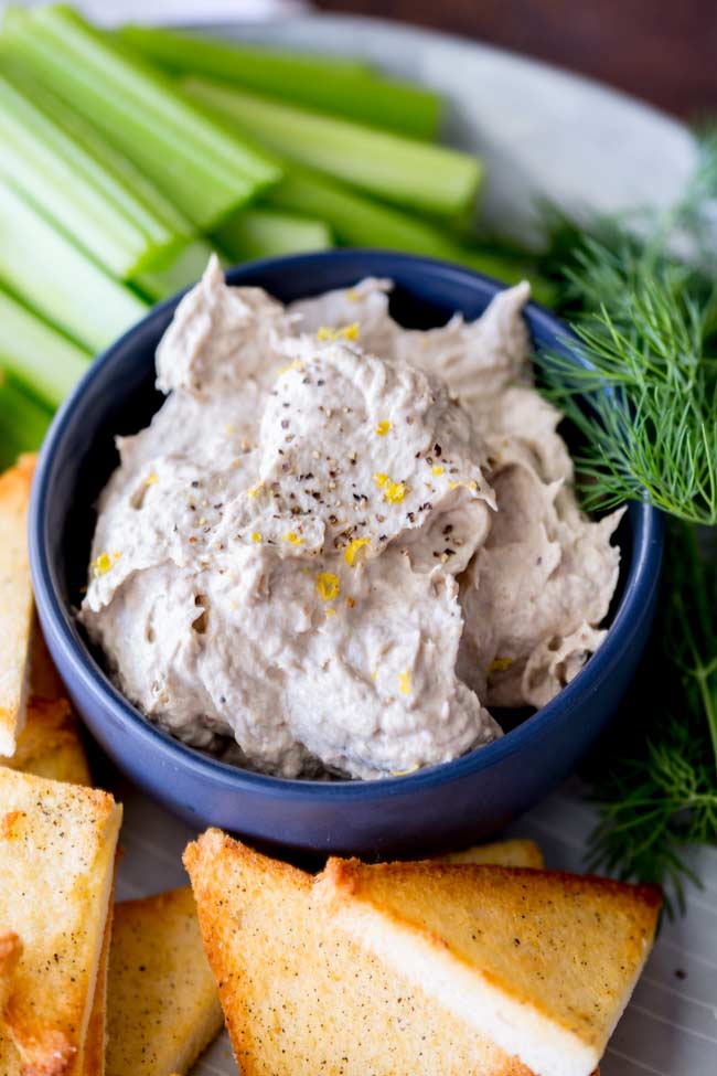 overhead of the smoked fish dip in a bowl with toast points and celery batons arranged around the edge