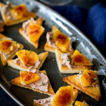 sq image from overhead showing the whole platter of toast and pate with caramelize orange