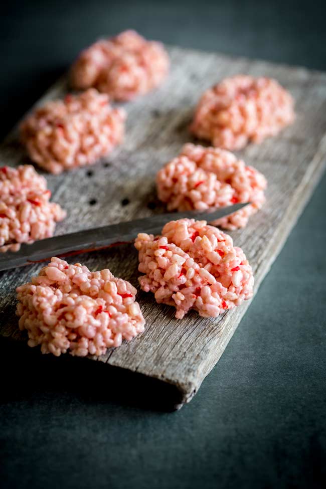 'bloody' knife hovering over rice krispies treat brains on a wooden board. 