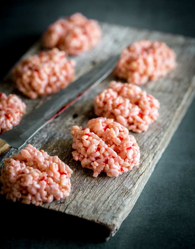 8 brains made from rice krispies on an old wooden board with a 'bloody' knife