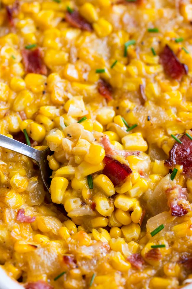 close up on a metal spoon scooping up creamed corn casserole