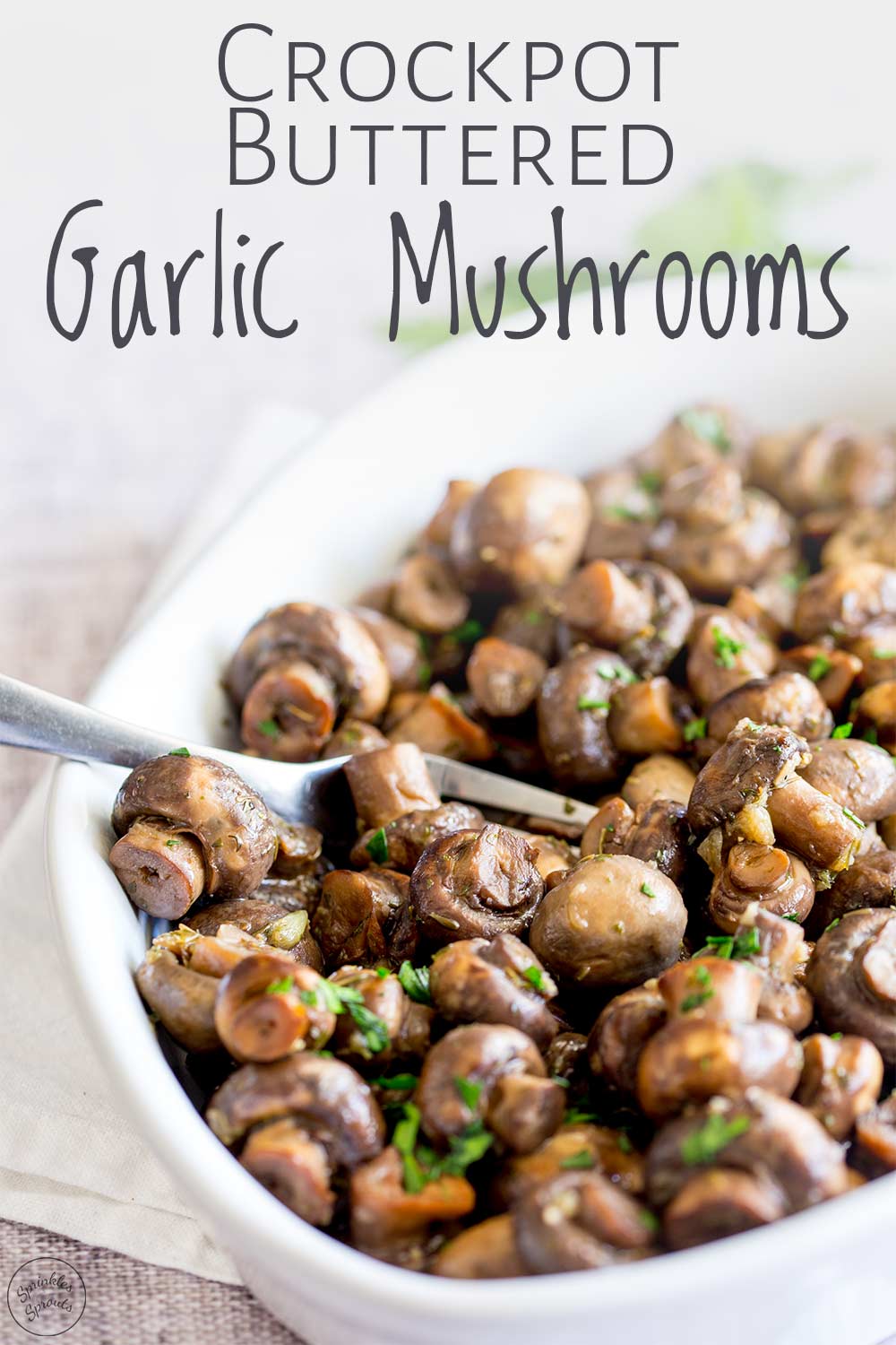 garlic mushrooms in a white serving dish with a metal fork in the dish with text at the top