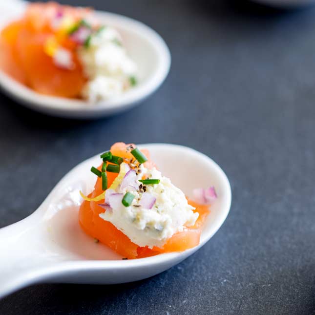 square photo showing a close up on the smoked salmon amuse spoon