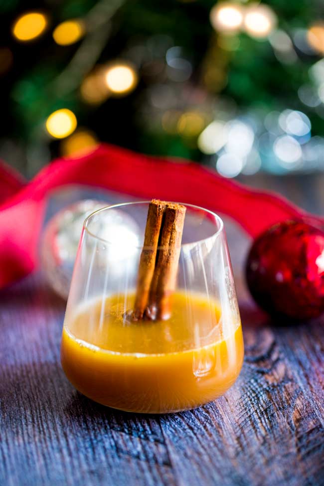 a single glass of hot buttered bourbon, garnished with a cinnamon stick