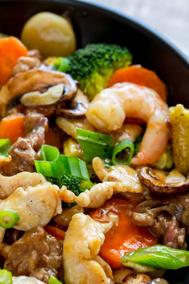 Chicken, beef, shrimp and vegetables in a black wok