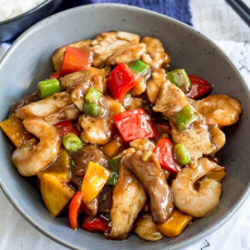 a great bowl with chicken, shrimp and bell peppers in a brown Chinese sauce