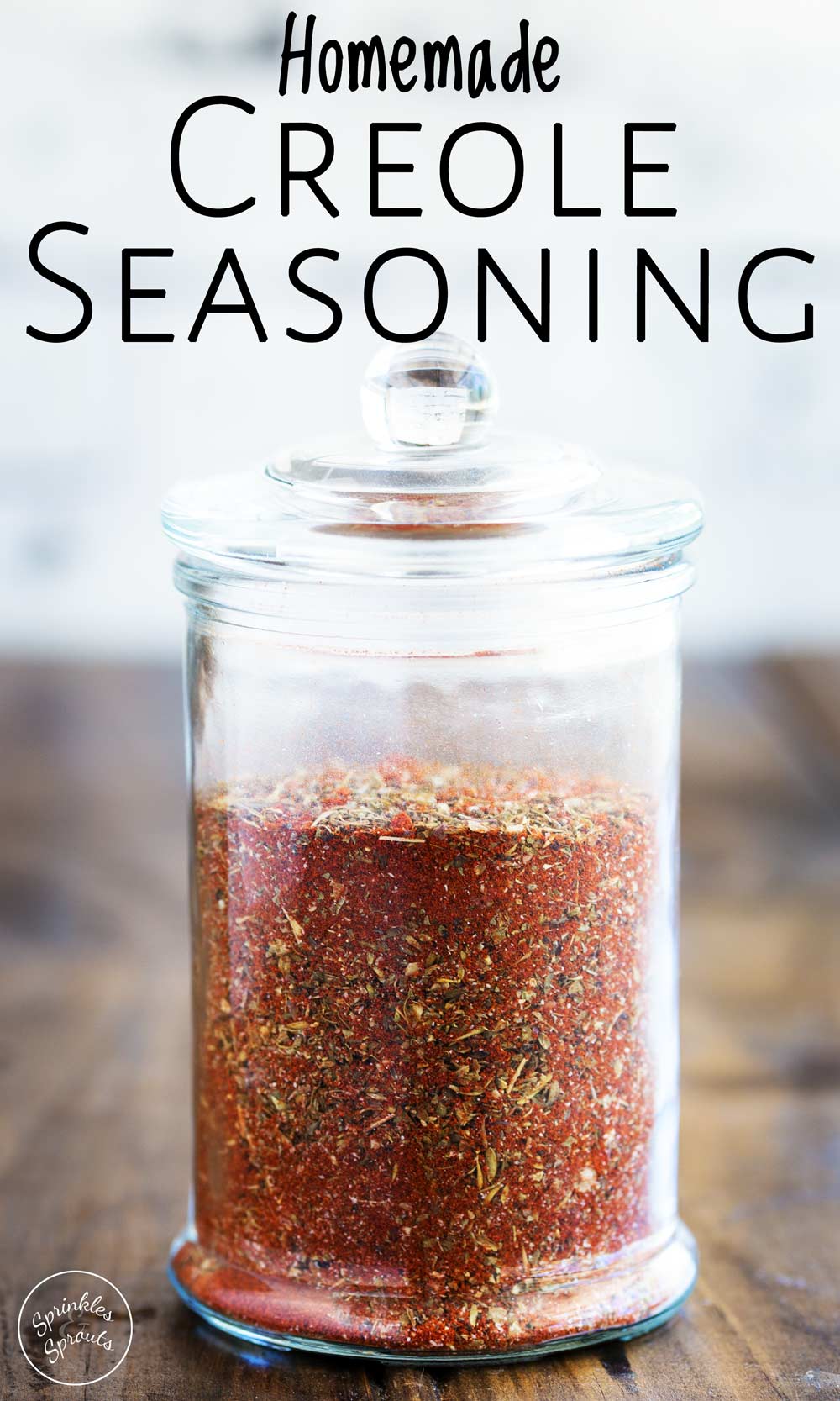 jar of creole seasoning on a wooden table with text at the top