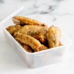 close up on the takeaway container of leftover chicken wings