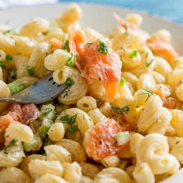 a fork lifting up smoked salmon pasta salad with spiral pasta
